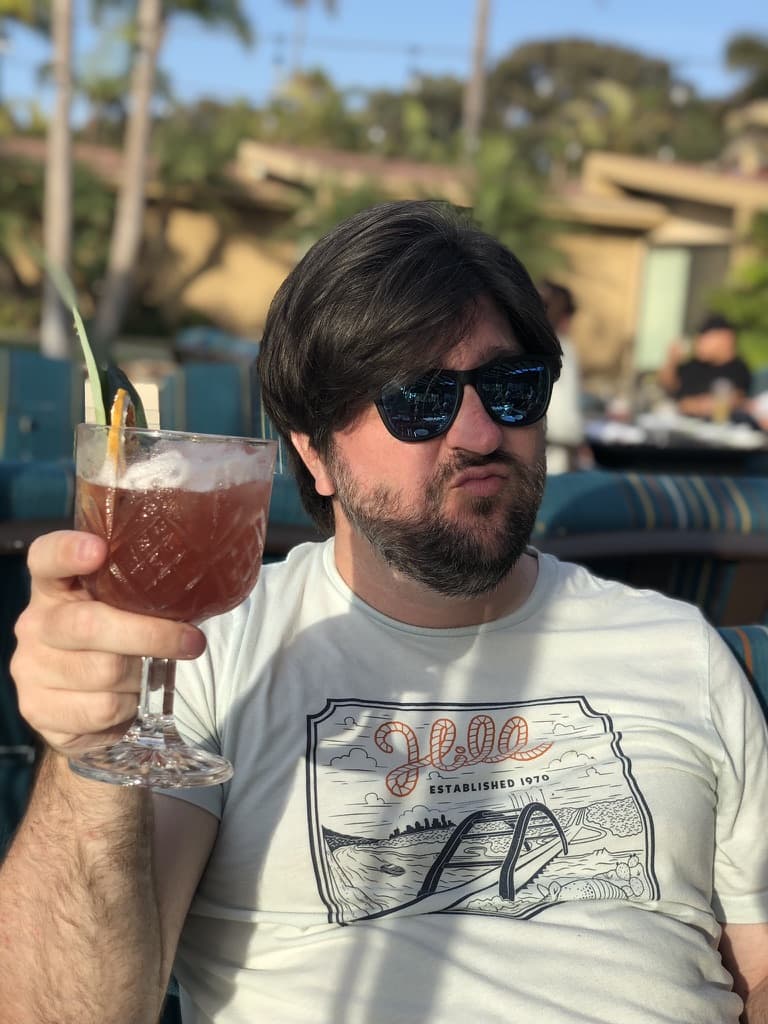 Me in sunglasses drinking a fancy pink beverage out of a large glass chalise