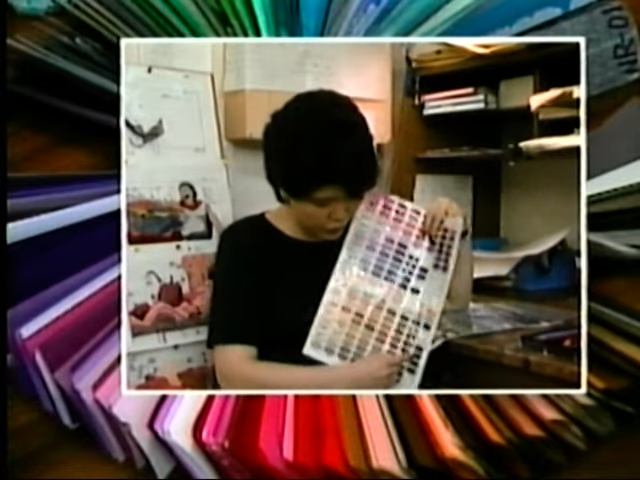 Kimie Yamada holding and pointing towards the darker browns at the bottom of the reds and pinks color palette sheet