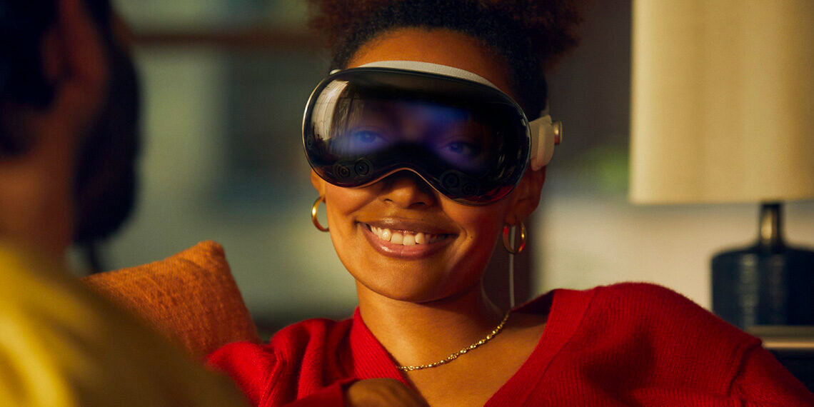 a smiling woman in an apple vision spatial reality headset with projected eyes