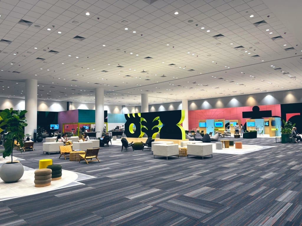 The main exhibition hall of Moscone center. A giant room with 12 foot tall ideographs in the middle of the room surrounded by couches and vendor kiosks