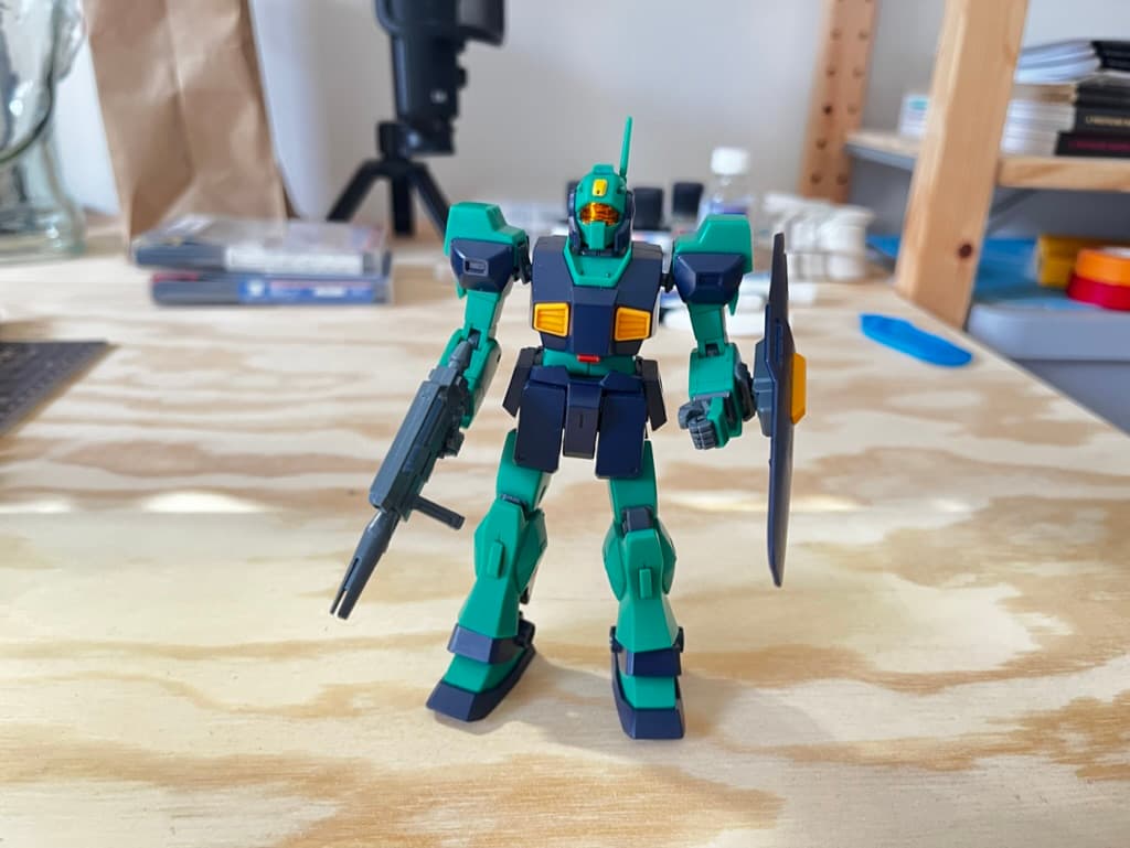 A 5” tall plastic navy blue and green robot mech model from the anime series Gundam